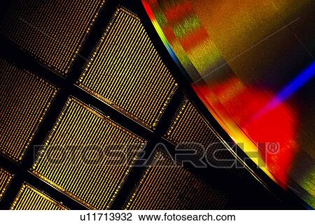 Stock Image - Close-up of a microchip wafer and a compact disk. Fotosearch
