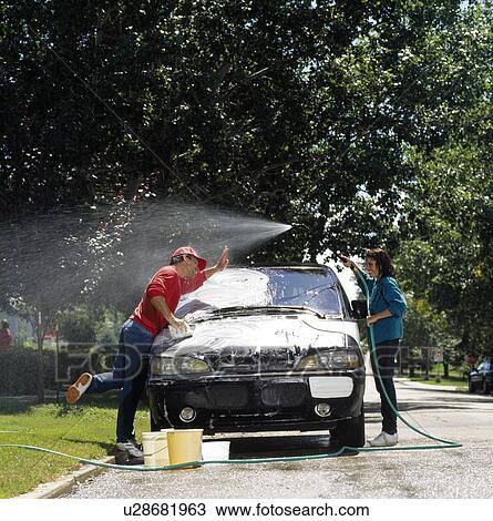 Stock Image - Couple washing the car. Fotosearch