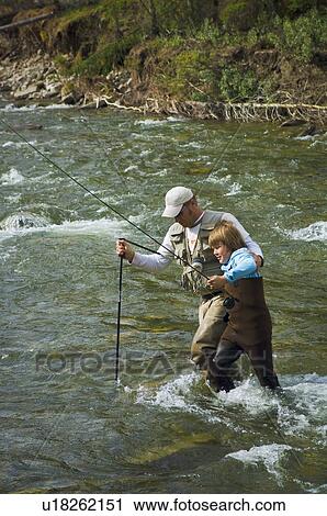 Father and son crossing a mountain fly fishing river View Large Photo Image Stock Image - Father and son crossing a mountain fly fishing river . Fotosearch