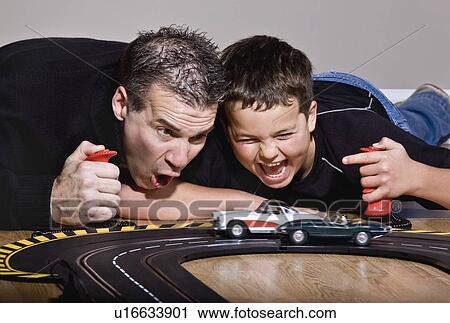 Father and son playing with race cars View Large Photo Image Stock Image - Father and son playing with race cars. Fotosearch