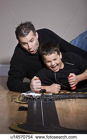 Father and son playing with race track View Large Photo Image Picture - Father and son playing with race track. Fotosearch