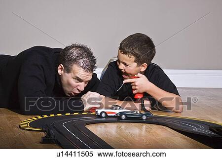 Father and son playing with race track View Large Photo Image Stock Photography - Father and son playing with race track. Fotosearch