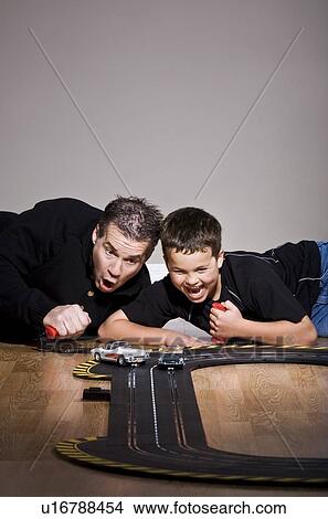 Picture - Father and son playing with toy race track. Fotosearch
