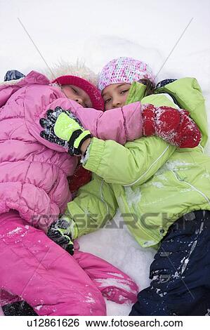 Friends lying in the snow View Large Photo Image Stock Photograph - Friends lying in the snow . Fotosearch