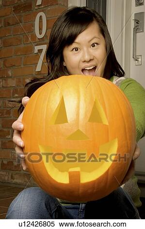 Stock Photography - Girl holding jack-o-lantern. Fotosearch