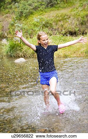 Stock Image - Girl running through water . Fotosearch