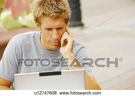 Man behind a laptop View Large Photo Image Stock Photo - Man behind a laptop. Fotosearch