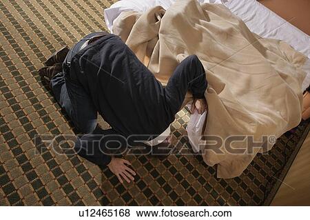 Man looking for something under the bed View Large Photo Image Stock Photo - Man looking for something under the bed. Fotosearch