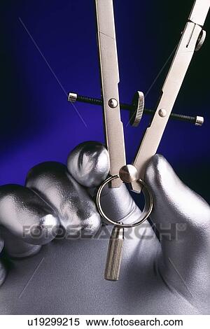 Silver hand holding drafting compass View Large Photo Image Stock Photography - Silver hand holding drafting compass. Fotosearch