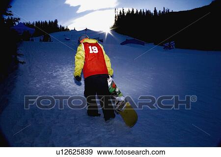 Snowboarder climbing up ski hill, Kananaskis, Alberta, Canada View Large Photo Image Stock Photo - Snowboarder climbing up ski hill, Kananaskis, Alberta, Canada. Fotosearch