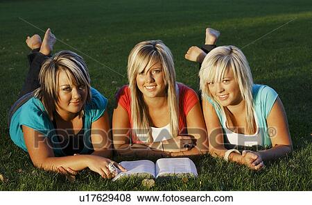 Stock Photo - Three girls reading together. Fotosearch