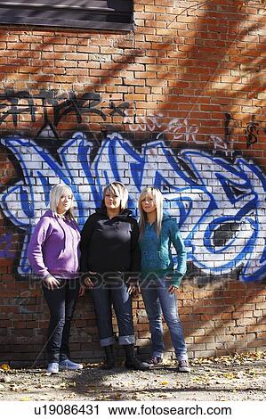 Three teens standing in front of graffiti View Large Photo Image Stock Image - Three teens standing in front of graffiti. Fotosearch