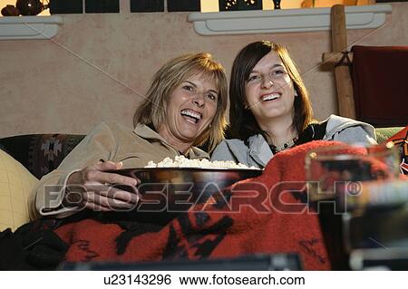 Two women watching a movie View Large Photo Image Stock Photograph - Two women watching a movie. Fotosearch