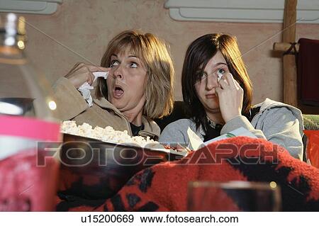 Stock Photo - Two women watching a sad movie. Fotosearch