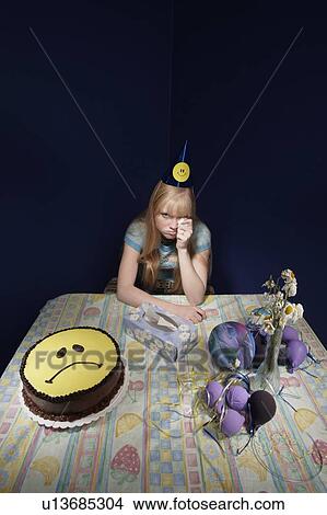 Picture - Upset girl surrounded by party supplies. Fotosearch