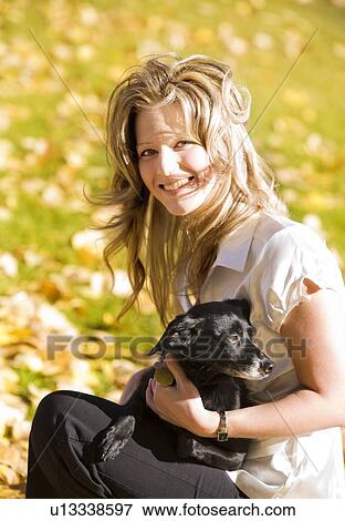 Woman holding a dog View Large Photo Image Stock Photo - Woman holding a dog. Fotosearch