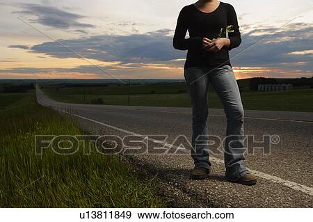 Woman standing at the side of the road View Large Photo Image Stock Photo - Woman standing at the side of the road. Fotosearch