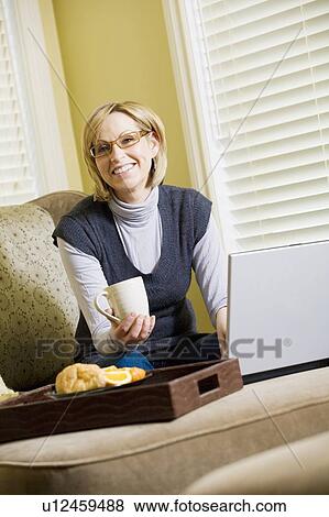 Woman working on laptop computer from home View Large Photo Image Stock Photo - Woman working on laptop computer from home. Fotosearch