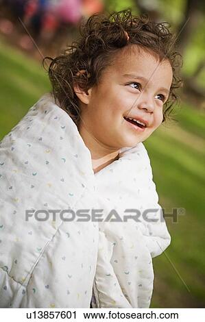 Stock Image - A girl wrapped in a blanket. Fotosearch