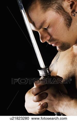 A man holding a sword View Large Photo Image Stock Image - A man holding a sword. Fotosearch