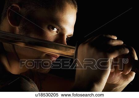 Stock Photography - A man holding a sword. Fotosearch