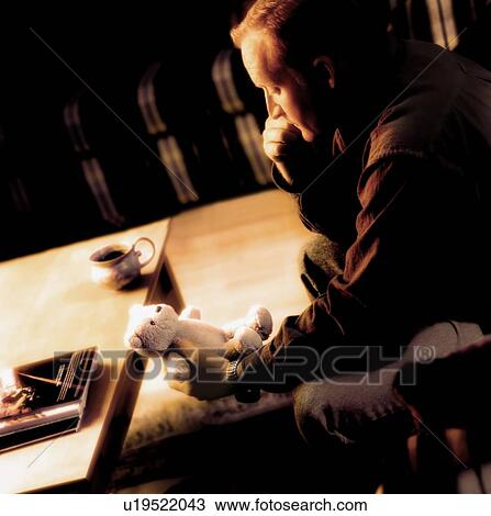 Stock Image - A man holding a teddy bear. Fotosearch