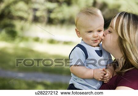 Stock Image - A mother kissing a boy. Fotosearch