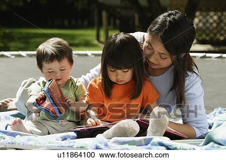 Stock Image - A mother reading to her children. Fotosearch