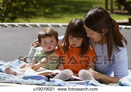 A mother reading to her children View Large Photo Image Stock Image - A mother reading to her children. Fotosearch
