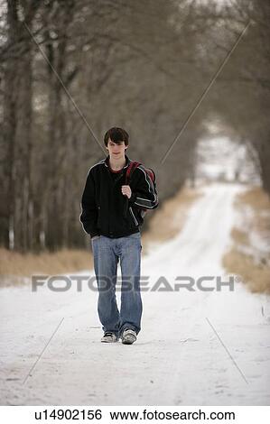 A teenage boy walking on a snow-covered path View Large Photo Image Stock Photograph - A teenage boy walking on a snow-covered path. Fotosearch