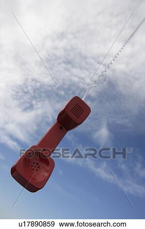 Stock Photo - A telephone receiver dangling from the sky. Fotosearch