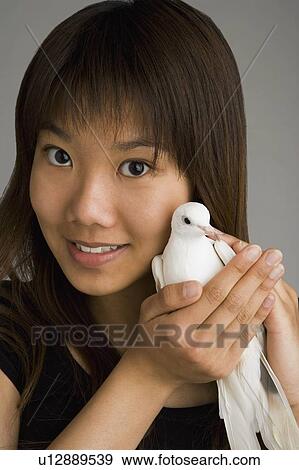 Stock Photo - A woman holding a dove. Fotosearch