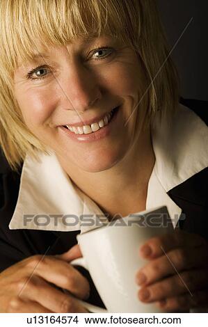 A woman holding a mug View Large Photo Image Picture - A woman holding a mug. Fotosearch