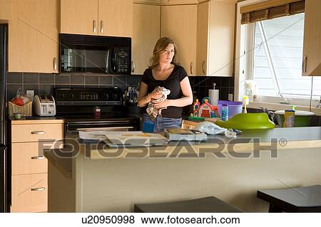 Stock Photo - A woman in a kitchen. Fotosearch