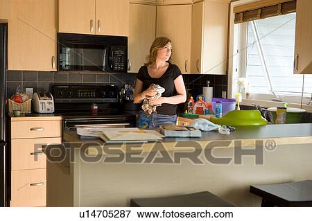Stock Photo - A woman in the kitchen. Fotosearch