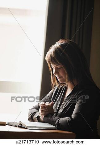 Stock Image - A woman praying. Fotosearch