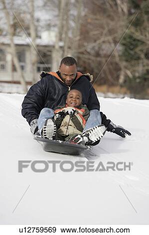 Father and son sledding on snow View Large Photo Image Stock Photo - Father and son sledding on snow. Fotosearch