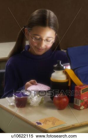 Girl eating lunch at desk View Large Photo Image Stock Photography - Girl eating lunch at desk. Fotosearch