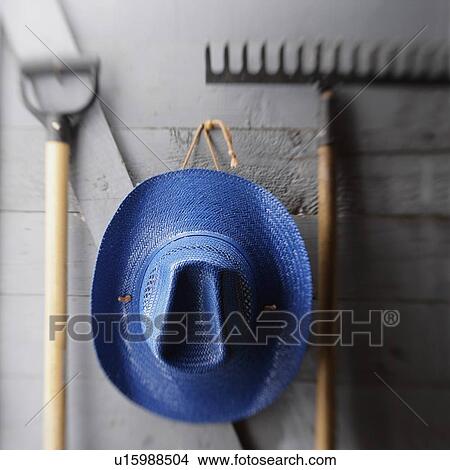 Hat hanging with gardening tools View Large Photo Image Picture - Hat hanging with gardening tools. Fotosearch
