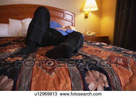 Man lying on bed View Large Photo Image Stock Image - Man lying on bed. Fotosearch