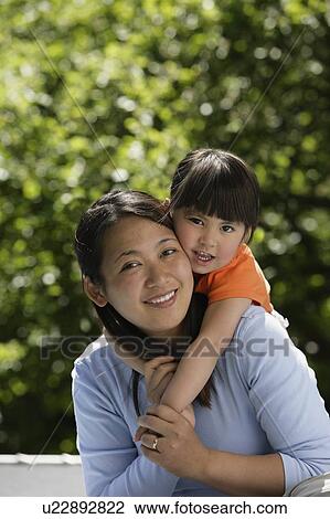Stock Image - Mother and daughter hugging. Fotosearch