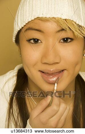 Woman applying lip gloss View Large Photo Image Stock Image - Woman applying lip gloss. Fotosearch