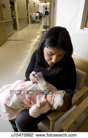 Woman bottle feeding baby girl View Large Photo Image Stock Image - Woman bottle feeding baby girl. Fotosearch