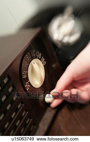 Woman changing dial on old radio View Large Photo Image Stock Photo - Woman changing dial on old radio. Fotosearch
