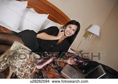 Woman on cellphone and laptop surrounded by shoes View Large Photo Image Picture - Woman on cellphone and laptop surrounded by shoes. Fotosearch
