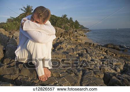 Woman on rocky shoreline View Large Photo Image Stock Photo - Woman on rocky shoreline. Fotosearch