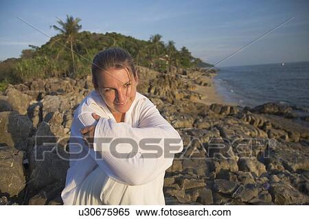 Stock Photography - Woman on rocky shoreline. Fotosearch