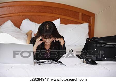 Woman working on bed View Large Photo Image Stock Photo - Woman working on bed. Fotosearch
