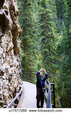 A boy using a camera in Johnson Canyon, Banff, Alberta, Canada View Large Photo Image Stock Photo - A boy using a camera in Johnson Canyon, Banff, Alberta, Canada. Fotosearch
