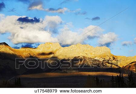 Blue sky with clouds over mountains in Jasper, Alberta, Canada View Large Photo Image Stock Photo - Blue sky with clouds over mountains in Jasper, Alberta, Canada. Fotosearch